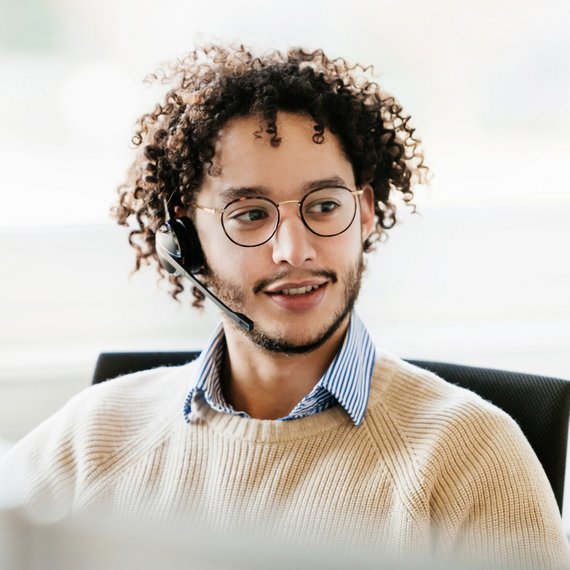 Individual wearing headset, cream sweater