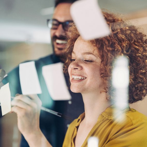 Person in yellow shirt holding pen and paper