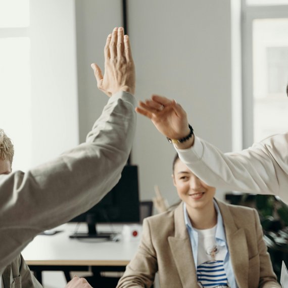 Two individuals in professional setting giving high-five