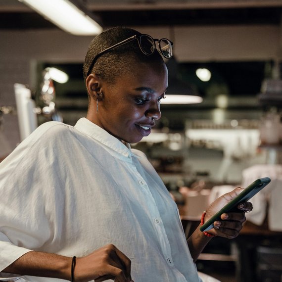 Person using smartphone in a kitchen setting