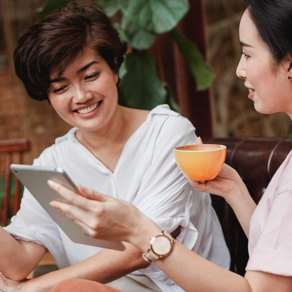 Two People in а Meeting with Tablet and Cup