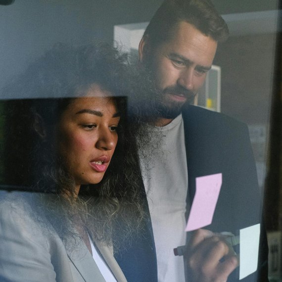 Two individuals in formal attire, one holding a pen