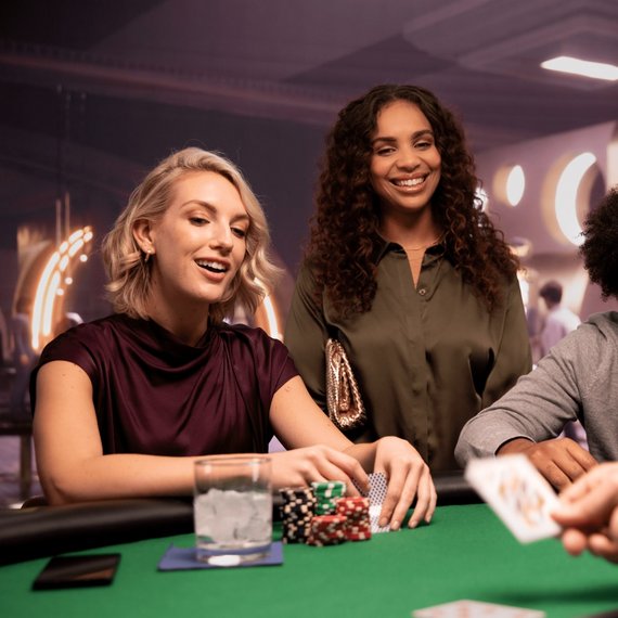 Three individuals playing poker with chips and cards on table