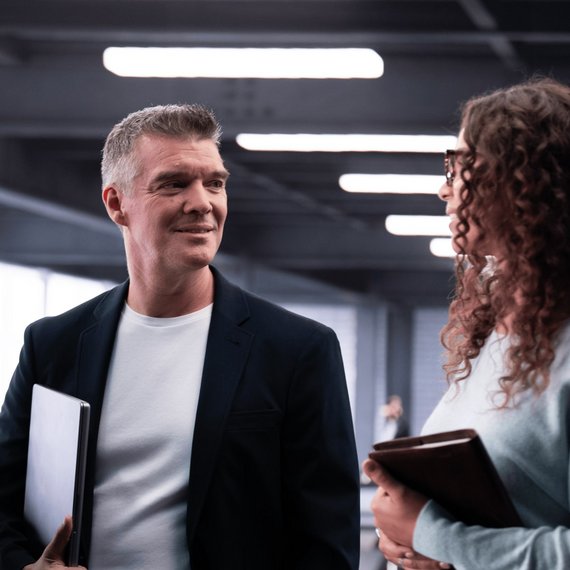 Two Individuals in Conversation in a Modern Indoor Setting