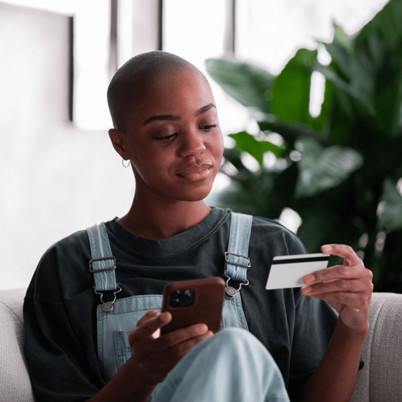 Person on Couch with Phone and Credit Card