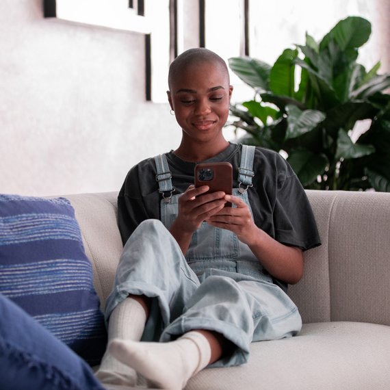 Individual on couch with smartphone
