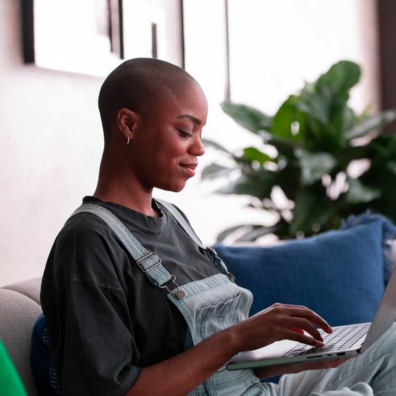 Individual on couch using laptop