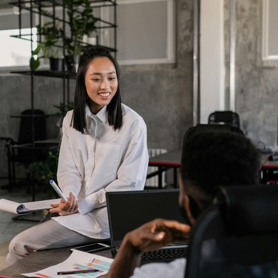 Two individuals, office setting, laptop in use