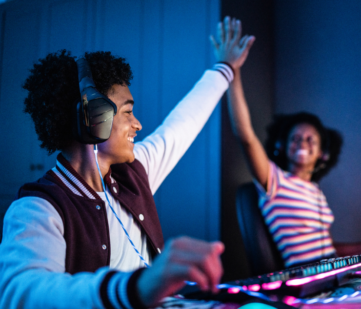 Two individuals with headphones playing video game