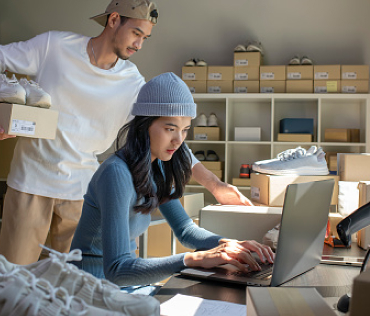 Two people managing shoe inventory in a small business warehouse