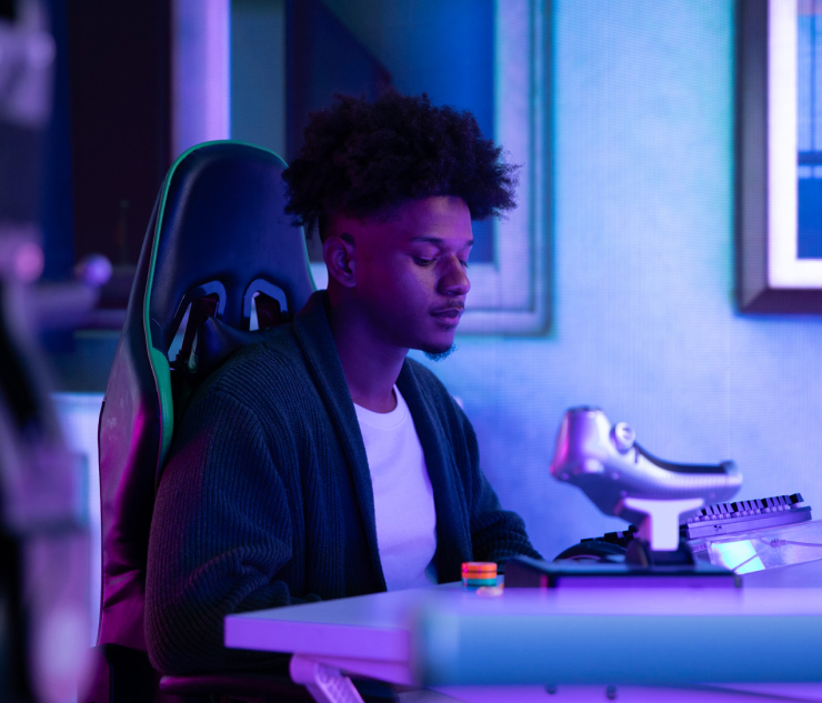 Person at desk with computer monitor, blue ambient lighting